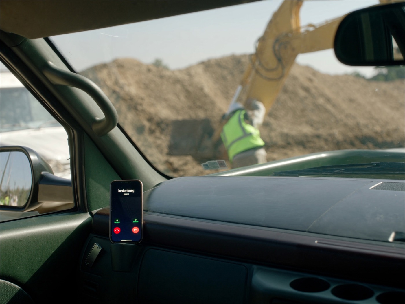 A phone ringing inside a work truck while the owner runs an excavator outside